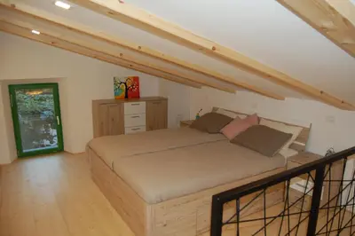 a bedroom with a large bed in a attic at Apartma HIŠKA in Dobravlje