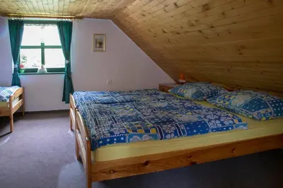 a bedroom with a bed in a wooden house at Hiška ob potoku in Dobrna