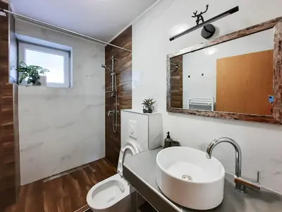 a bathroom with a sink and a mirror at Deerwood-2-Storey Garden Apartment with Castle view Balcony in Bled