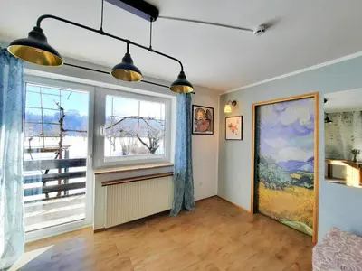 a living room with a large window and blue curtains at Deerwood-2-Storey Garden Apartment with Castle view Balcony in Bled