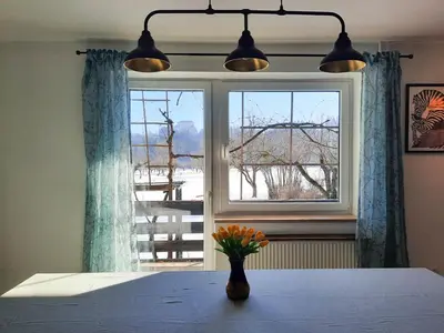 a vase of flowers sitting on a table in front of a window at Deerwood-2-Storey Garden Apartment with Castle view Balcony in Bled