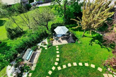 an overhead view of a garden with a house and a pool at Deerwood-2-Storey Garden Apartment with Castle view Balcony in Bled