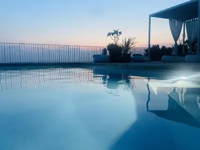 a swimming pool with the reflection of the sunset at VILLA ZEROU in Kojsko