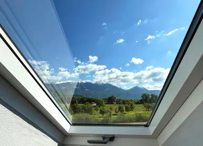 a skylight window with a view of the mountains at Deerwood-Sky Attic with Bled Castle View-NO KITCHEN in Bled