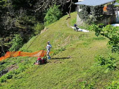 two people standing on a hill with an orange net at Healing Farm in Gorenja Vas