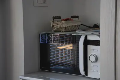 a microwave oven with a basket on top of it at Zemva Stays - JT Apartma, free bikes, big garden with terrace in Bled