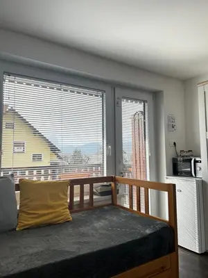 a bedroom with a bed and a large window at Zemva Stays - JT Apartma, free bikes, big garden with terrace in Bled