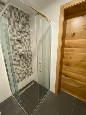 a shower with a glass door in a bathroom at Apartma LUPIS in Podvolovljek