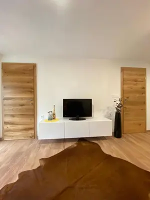a living room with a tv on a white cabinet at Apartma LUPIS in Podvolovljek