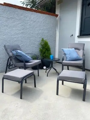 three chairs and a table with blue pillows on a patio at Hiška Orel Terme Čatež in Čatež ob Savi