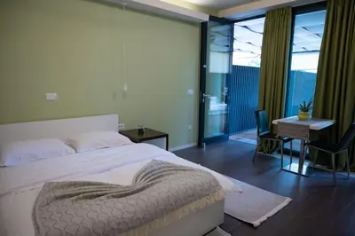 a bedroom with a bed and a table and a desk at Hana - Apartments in Ljubljana