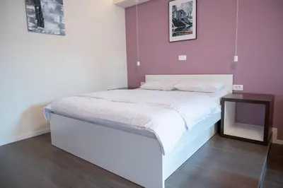 a bedroom with a white bed and a tv at Hana - Apartments in Ljubljana