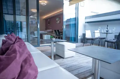 a living room with tables and chairs and a dining room at Hana - Apartments in Ljubljana