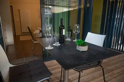 a table with wine glasses and a bottle of wine at Hana - Apartments in Ljubljana