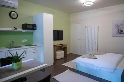 a bedroom with a bed and a sink and a desk at Hana - Apartments in Ljubljana