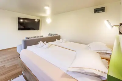 two beds in a room with a tv on the wall at Mobile House Vegov hram in Dol pri Ljubljani