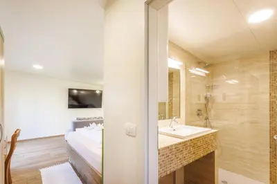 a bathroom with a shower and a sink and a bed at Mobile House Vegov hram in Dol pri Ljubljani