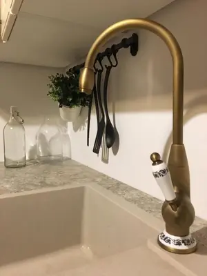 a kitchen sink with a faucet next to a sink at Loghouse Brunka - Escape from life on a highway in Gornja Radgona