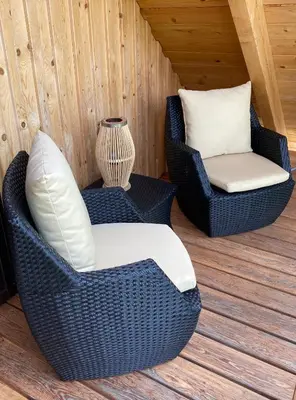 two wicker chairs and a vase on a deck at Loghouse Brunka - Escape from life on a highway in Gornja Radgona