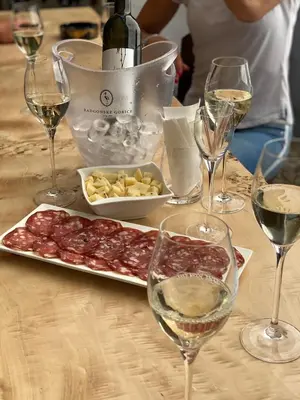 a table with glasses of wine and a plate of food at Loghouse Brunka - Escape from life on a highway in Gornja Radgona