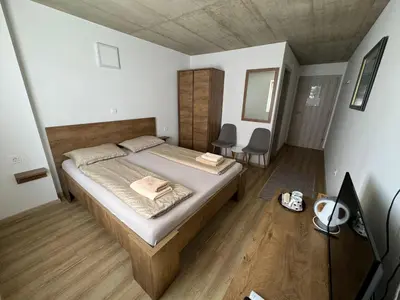 a bedroom with a bed and two chairs in it at Sobe, Rooms B&B - Vina Kauran in Zgornji Jakobski Dol
