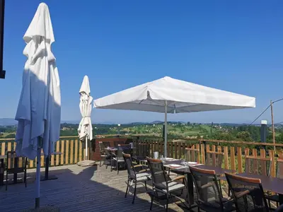 a patio with tables and umbrellas on a deck at Sobe, Rooms B&B - Vina Kauran in Zgornji Jakobski Dol