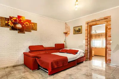 a bedroom with a red couch in a room at Holiday Homes I&G by the river next to Olimje in Kozje