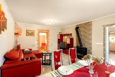 a living room with a red couch and a table at Holiday Homes I&G by the river next to Olimje in Kozje