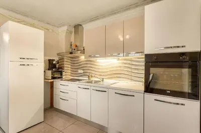a kitchen with white cabinets and a sink at Holiday Homes I&G by the river next to Olimje in Kozje