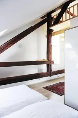 a bedroom with a white bed and a staircase at Apartments Katrca Ljubljana in Ljubljana