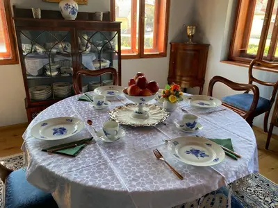 a table with plates and cups and a bowl of fruit at Villa Ruska dača in Ljubljana