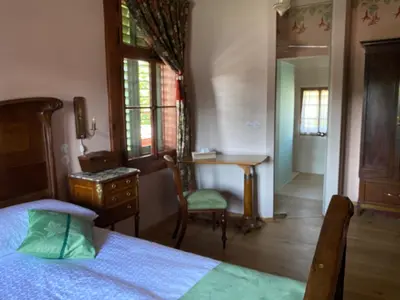 a bedroom with a bed and a desk and a table at Villa Ruska dača in Ljubljana