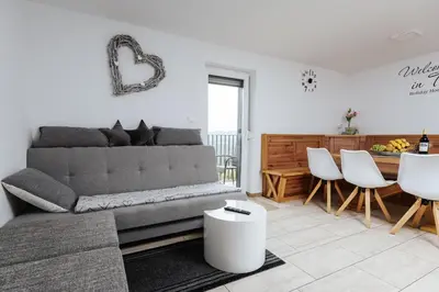 a living room with a couch and a table at Tanja s Holiday Home in Nature with sauna and hot tub in Gorica pri Slivnici