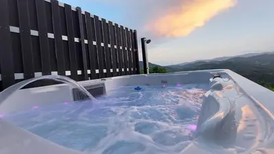 a jacuzzi tub with a person in it at Tanja s Holiday Home in Nature with sauna and hot tub in Gorica pri Slivnici