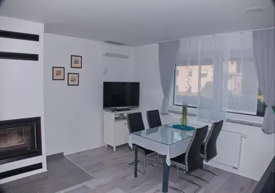 a dining room with a table and chairs and a television at Apartmaji Anita in Begunje pri Cerknici