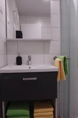 a bathroom with a sink and green towels at Apartmaji Anita in Begunje pri Cerknici
