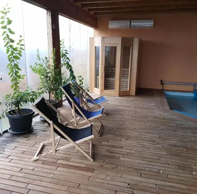 two chairs sitting on a patio next to a pool at Country House Zemljanka in Šentrupert