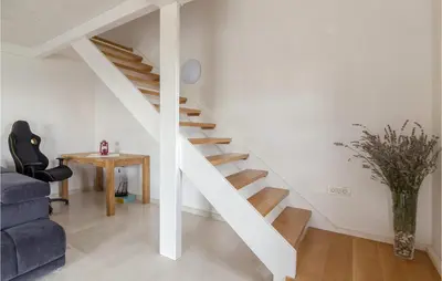 a white staircase in a living room with a blue couch at Lovely Home In Kojsko With Sauna in Kojsko