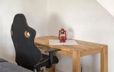 a chair sitting at a wooden table with a lantern at Lovely Home In Kojsko With Sauna in Kojsko