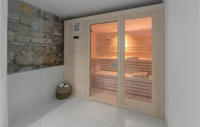 a room with a large wooden sauna with a stone wall at Lovely Home In Kojsko With Sauna in Kojsko