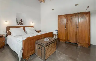 a bedroom with a bed and a wooden cabinet at Lovely Home In Kojsko With Sauna in Kojsko