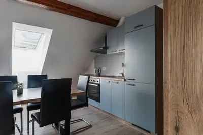 a kitchen with a table and a refrigerator at APARTMAJI GORENC in Bled