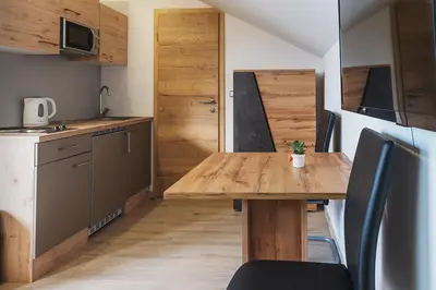 a small kitchen with a wooden table in a room at APARTMAJI GORENC in Bled
