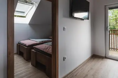 a mirror in a room with two beds and a window at APARTMAJI GORENC in Bled