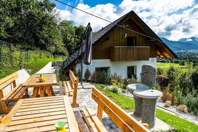 a patio with a wooden table and a building at APARTMAJI GORENC in Bled