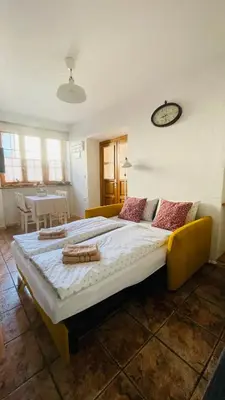 a large bed in a room with a clock on the wall at Apartma Cici in Kobarid