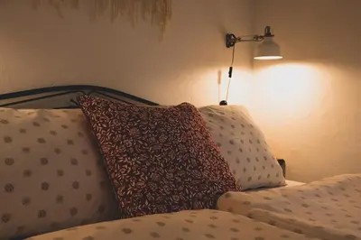 a bed with two pillows on it with a lamp at Apartma Cici in Kobarid