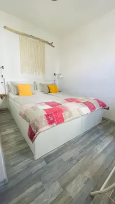 a bedroom with a bed with a red and yellow blanket at Apartma Cici in Kobarid