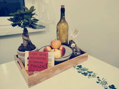 a bottle of wine and a bowl of apples and a plate of fruit at Počitniška hiša Pavlek in Ivanjkovci