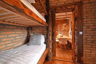 a bedroom with a bunk bed in a brick wall at Hiša stare mame in Kamnik